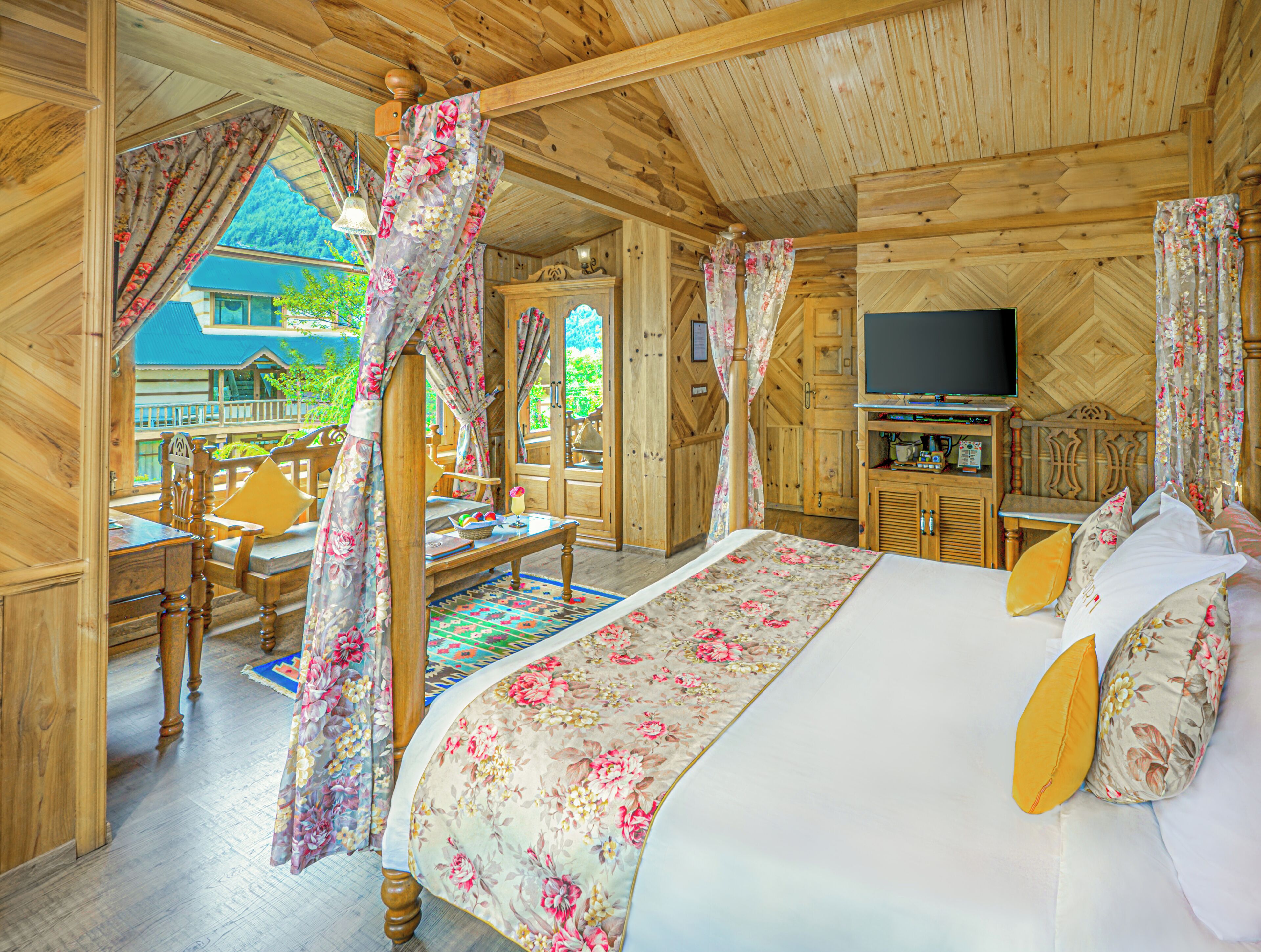 Een houten chalet met een bed, een televisie en een eethoek.