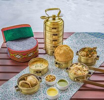 A table with various food items and containers, including a samosa, a samovar, and several bowls of food.