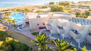 A resort with a swimming pool, sun loungers, and a beach view. - Akti Corali (Malevizi)