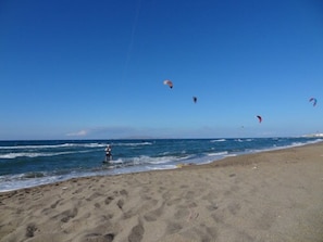 Na praia, espreguiçadeiras, guarda-sóis 