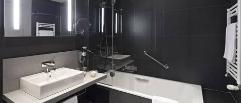 Un baño moderno con una bañera grande, un lavabo independiente y un espejo.