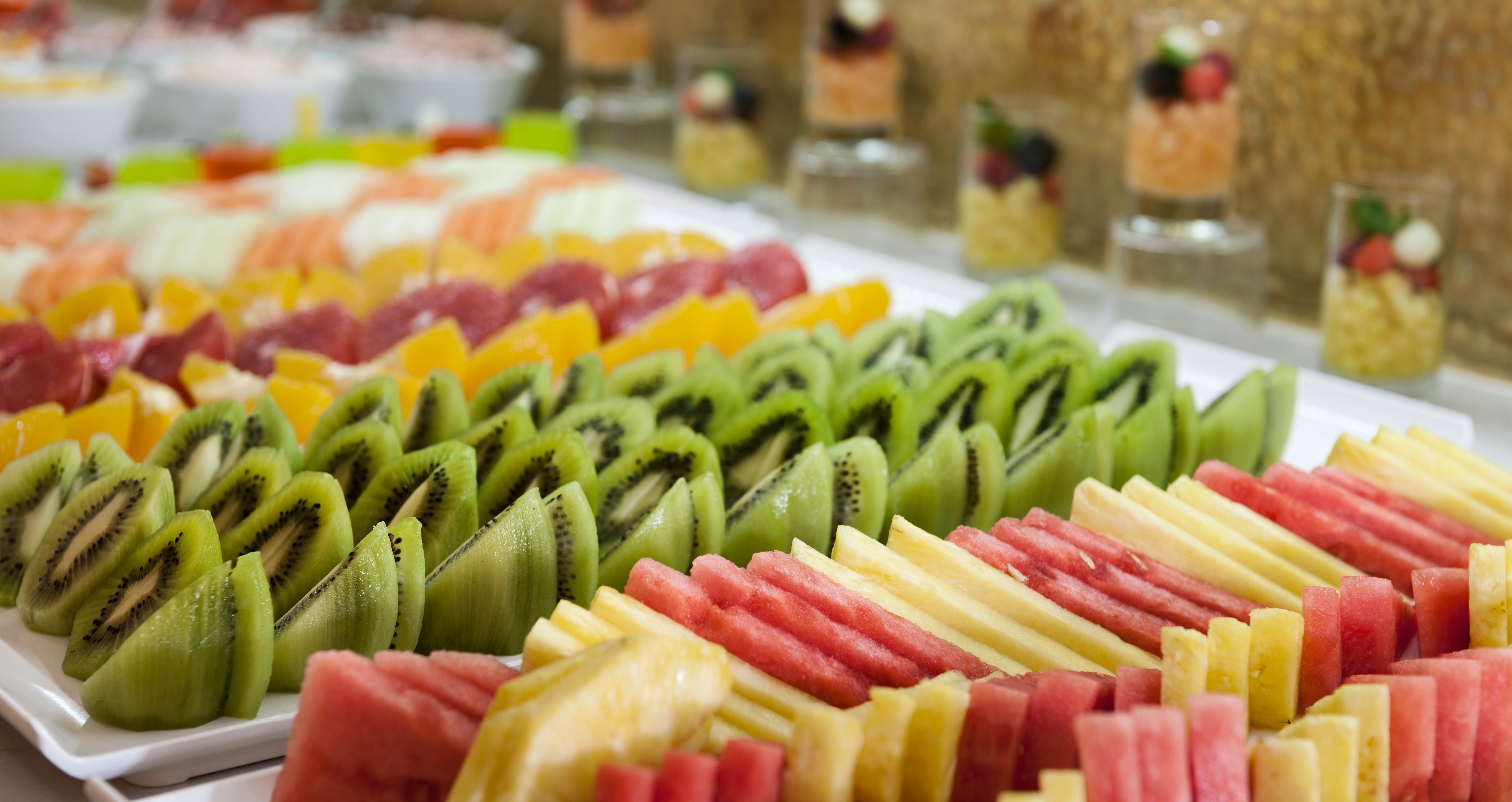 A buffet with various fruits and desserts.