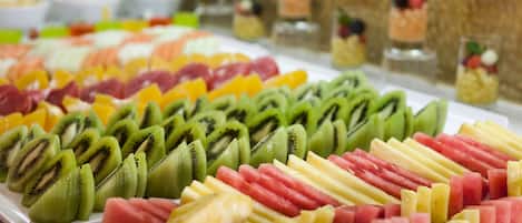 A buffet with various fruits and desserts.