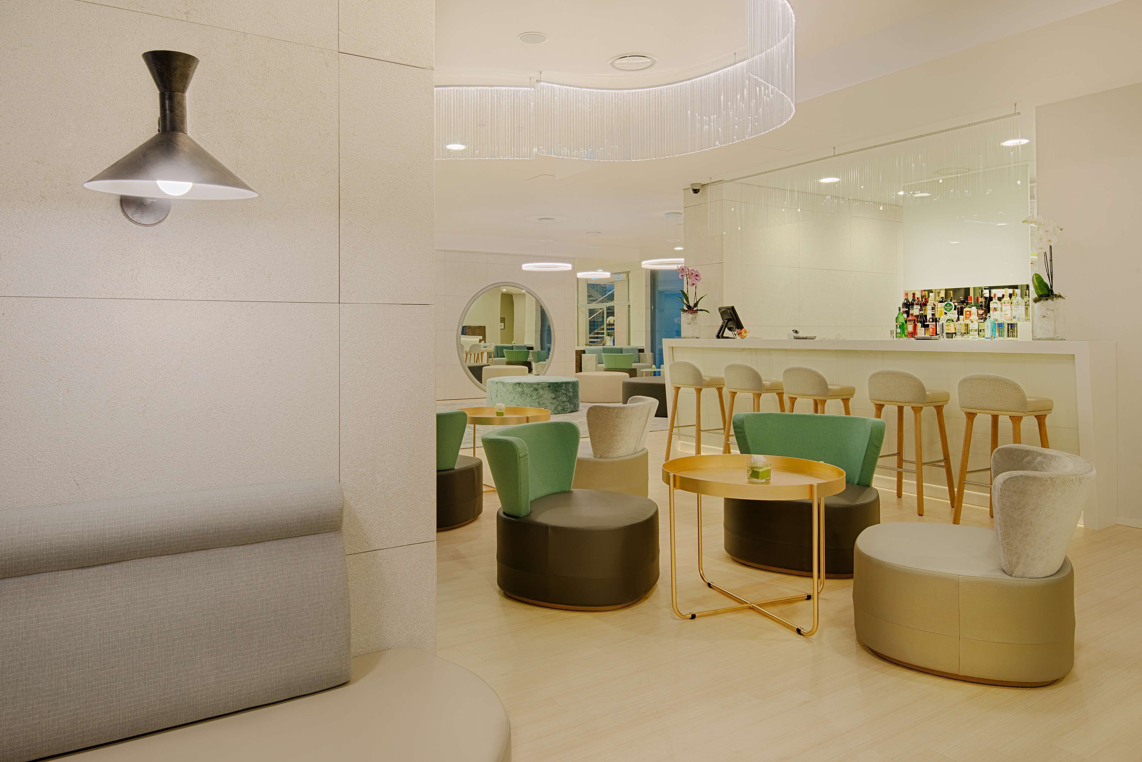 Un intérieur moderne avec des espaces de détente, un bar et un grand miroir.