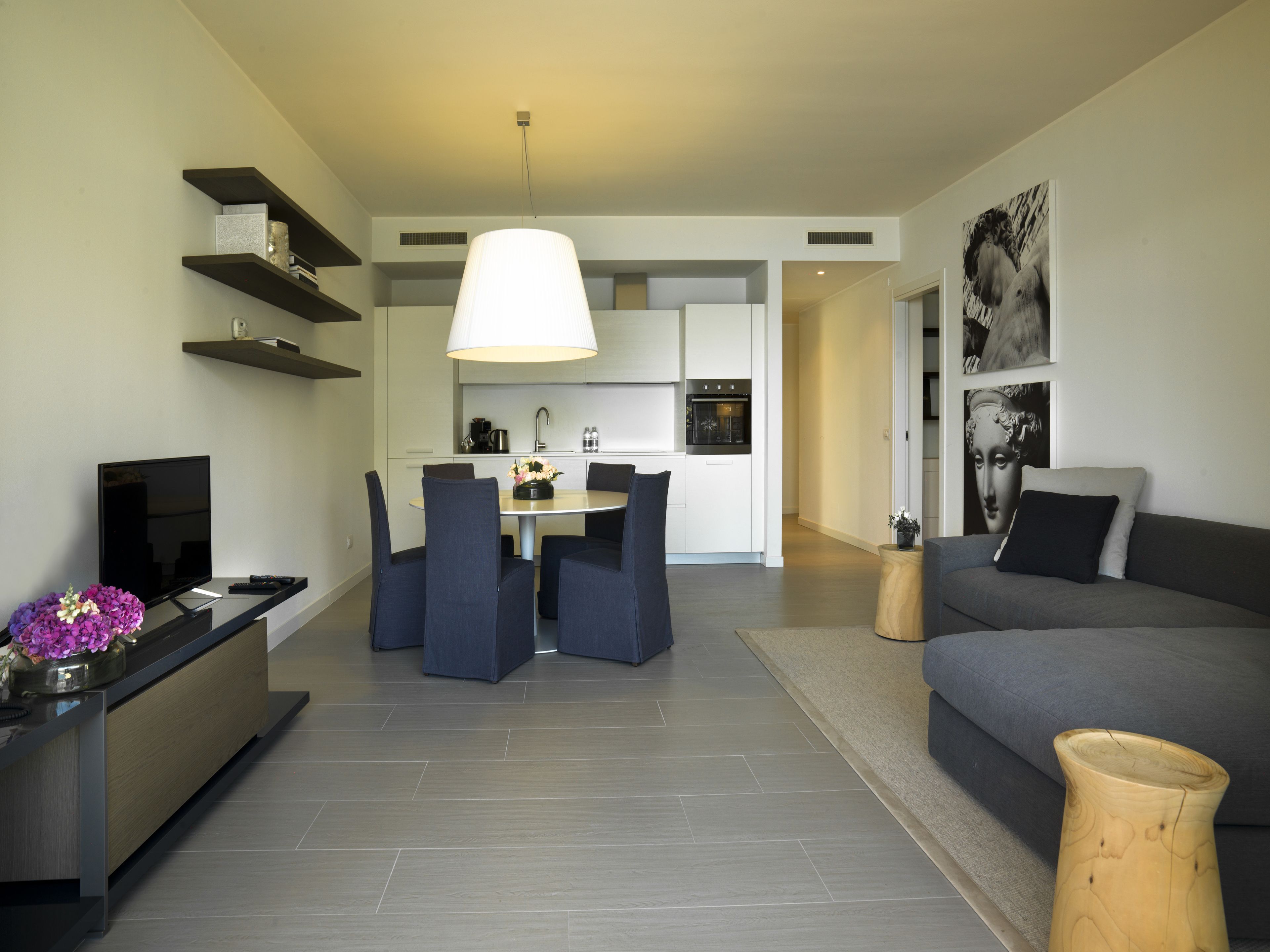 A modern living room with a sofa, TV, and dining area.