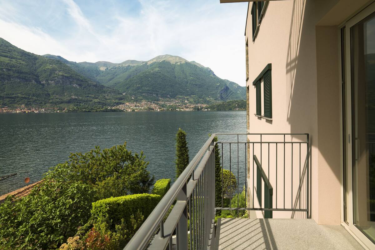 Een balkon met uitzicht op een meer en bergen.