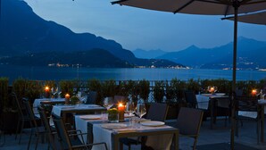 A table set for dining with a view of a lake and mountains in the background.