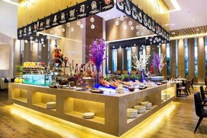 A buffet setup with a variety of food items, a decorative centerpiece, and a well-lit interior.
