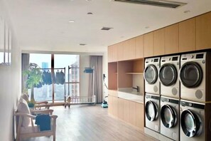 Een modern appartement met een wasruimte, een zithoek met uitzicht en een groot raam.