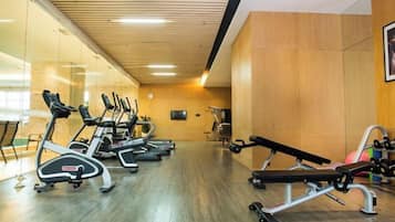 A gym with treadmills, a bench press, and weight machines.