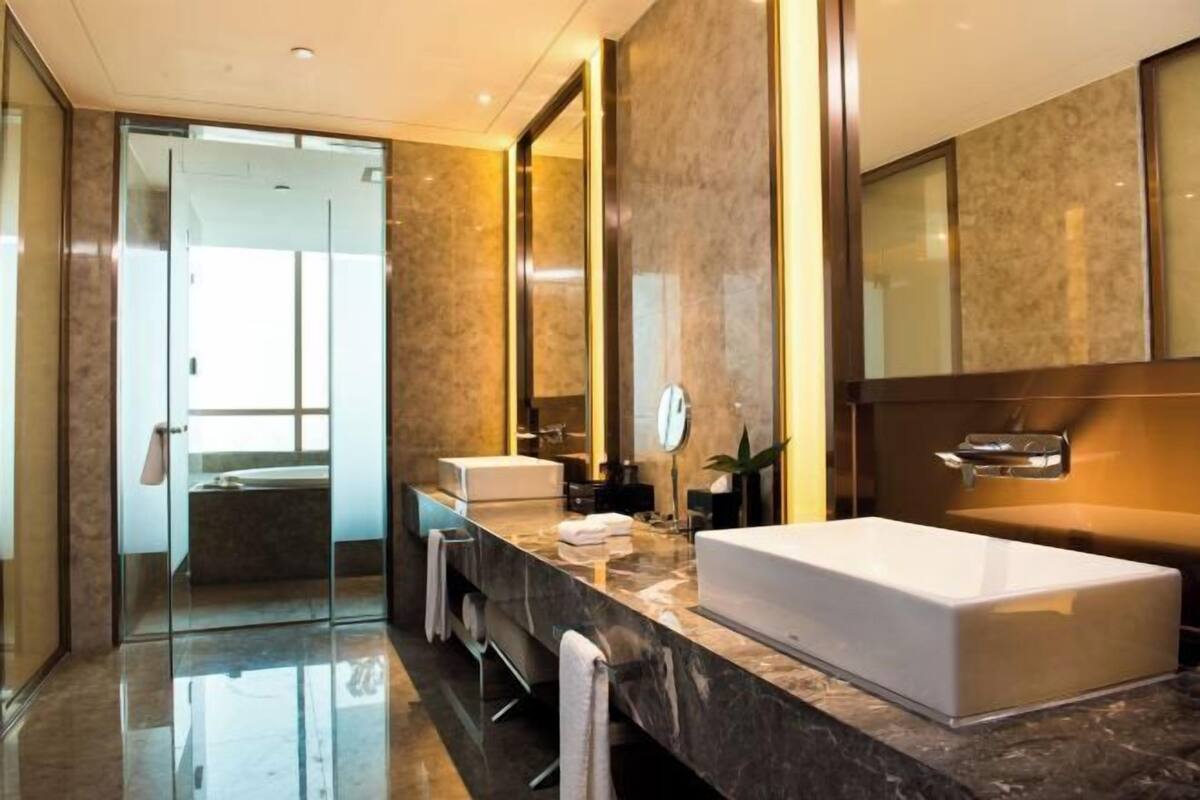 Une salle de bain moderne avec une grande baignoire blanche, une douche en verre et un comptoir en marbre.