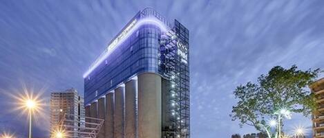 Standing tall in the heart of the city, this building features a striking curved glass facade and vertical columns.