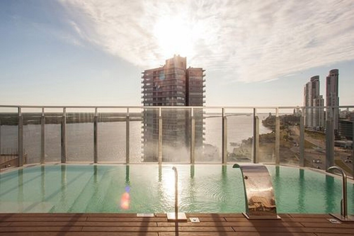 Una piscina cubierta, una piscina al aire libre, tumbonas