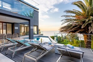 Piscine extérieure, parasols de plage, chaises longues