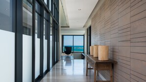 A modern hallway with large windows, a wooden wall, and a table with lamps. - Living Hotel Lions Eye (Cape Town)
