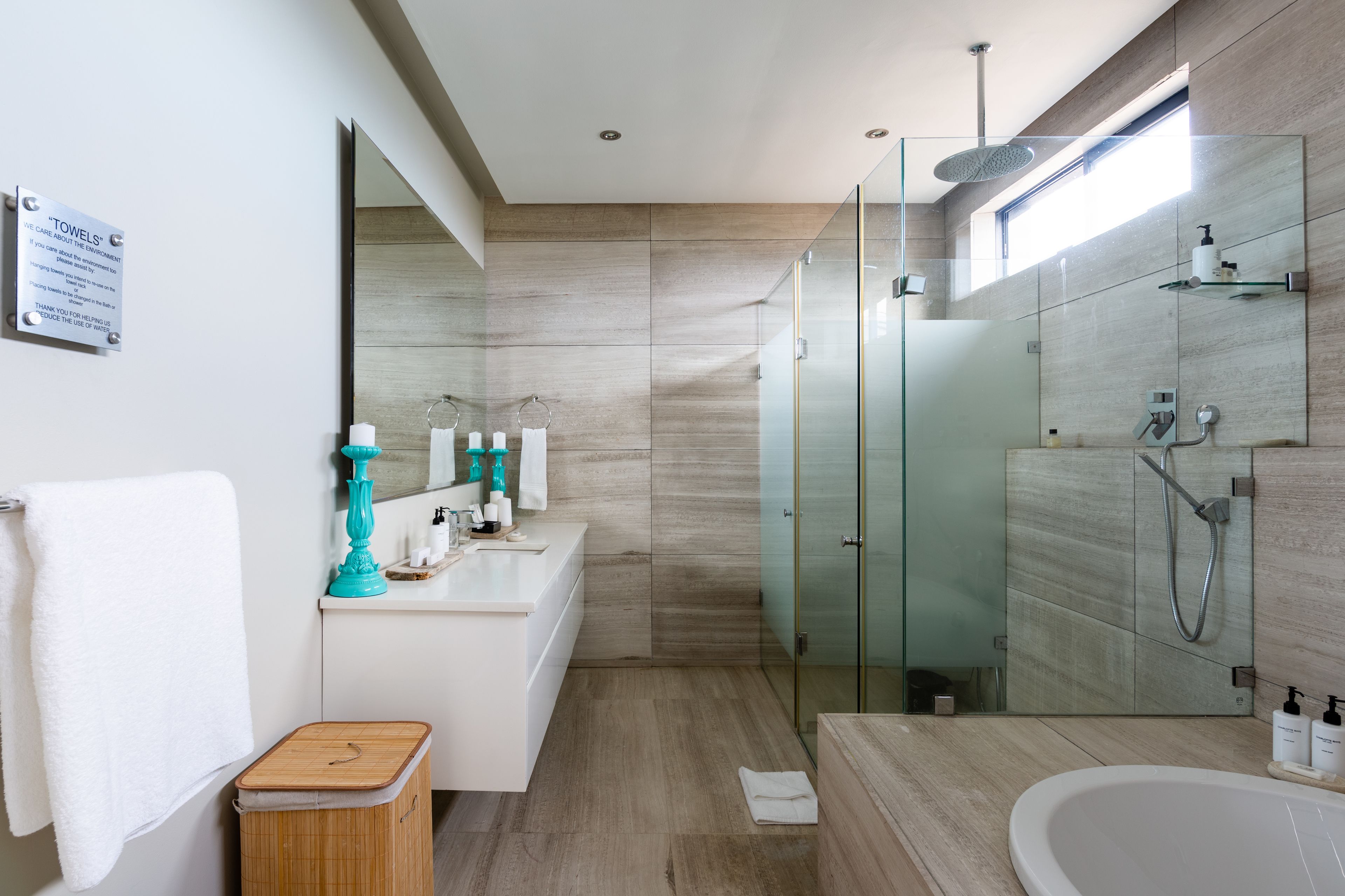 Une salle de bain moderne dotée d’une douche à parois de verre, d’une baignoire sur pieds et d’un meuble-lavabo avec miroir.