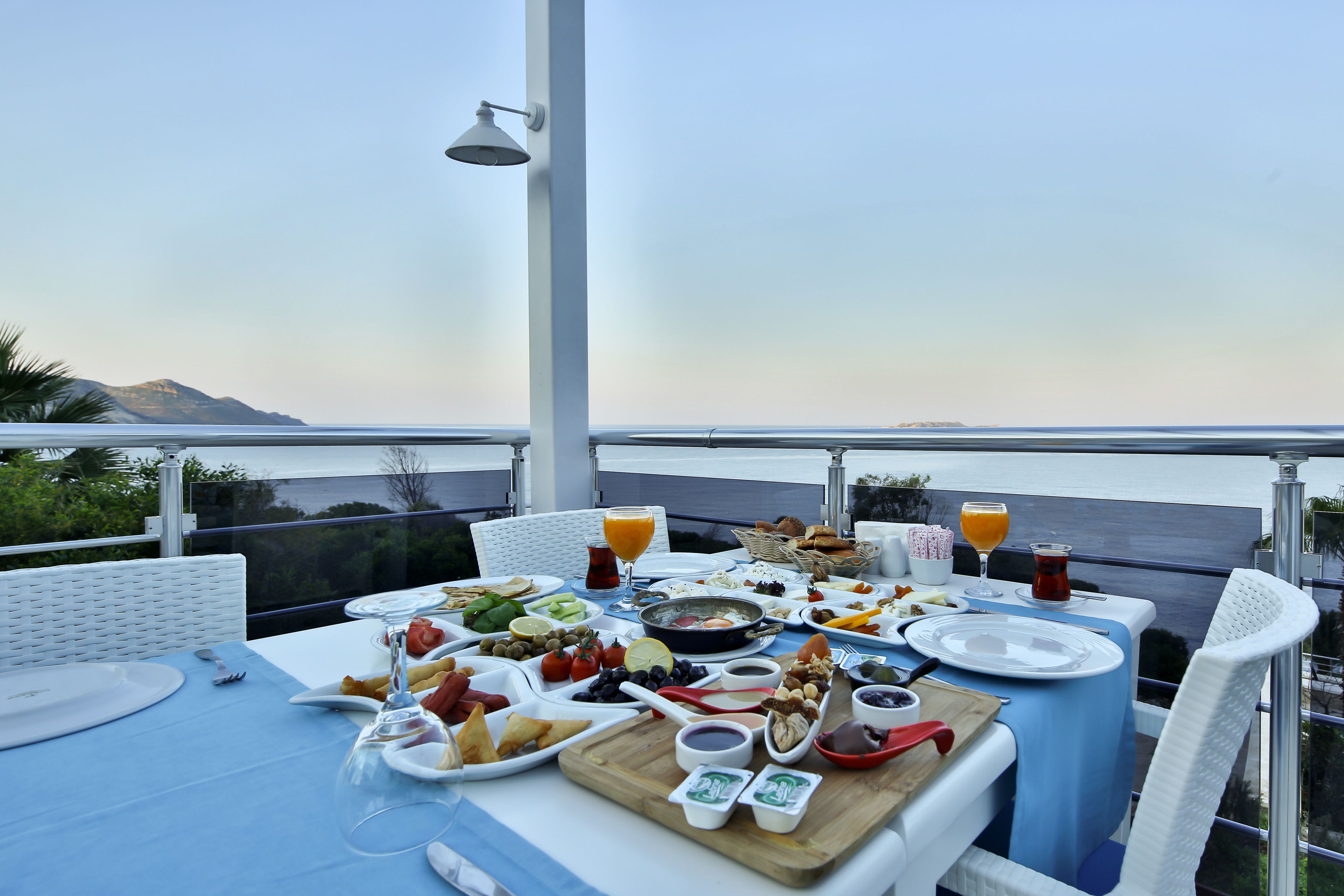 A table set for breakfast with a scenic view of the sea and mountains in the background.