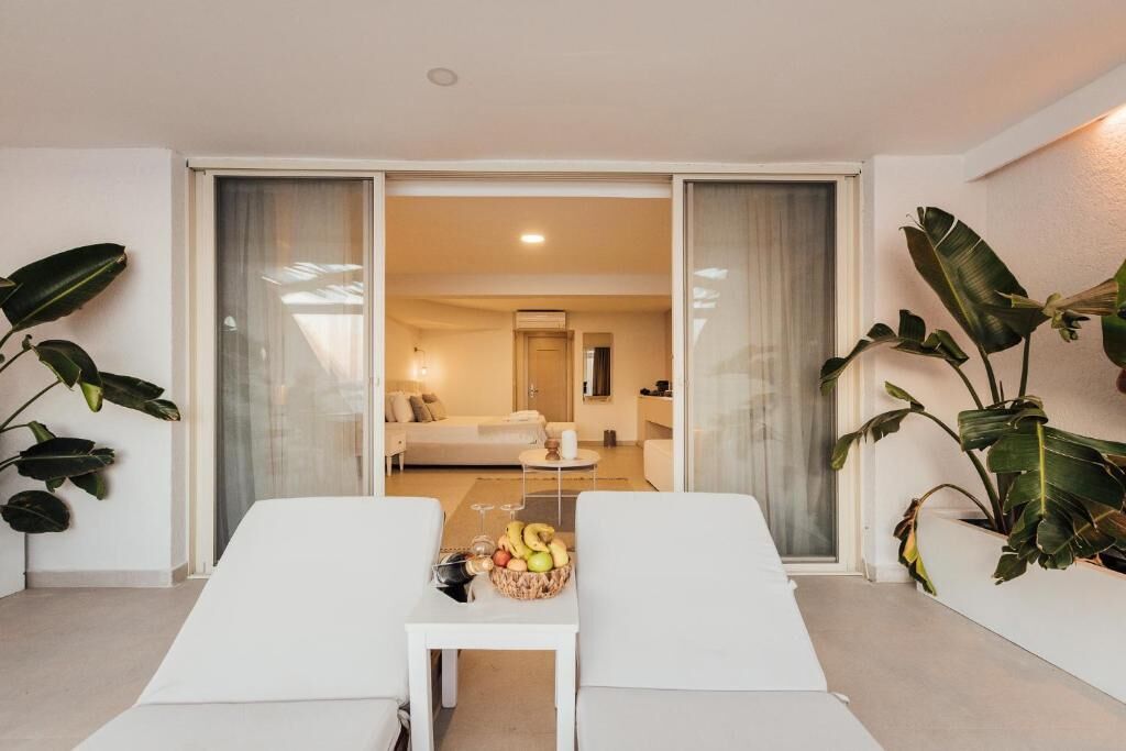 A modern living room with a sofa, a coffee table with fruit, and a view into another room.