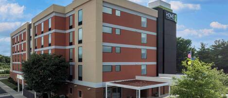 A multi-story hotel with a modern design, featuring a prominent 'HOME' sign on the side.