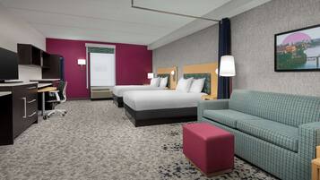 Une chambre d’hôtel comprenant un lit, un bureau, une chaise, un canapé et un téléviseur.