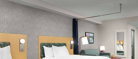 A hotel room with two beds, a large mirror, a nightstand, and a red ottoman.