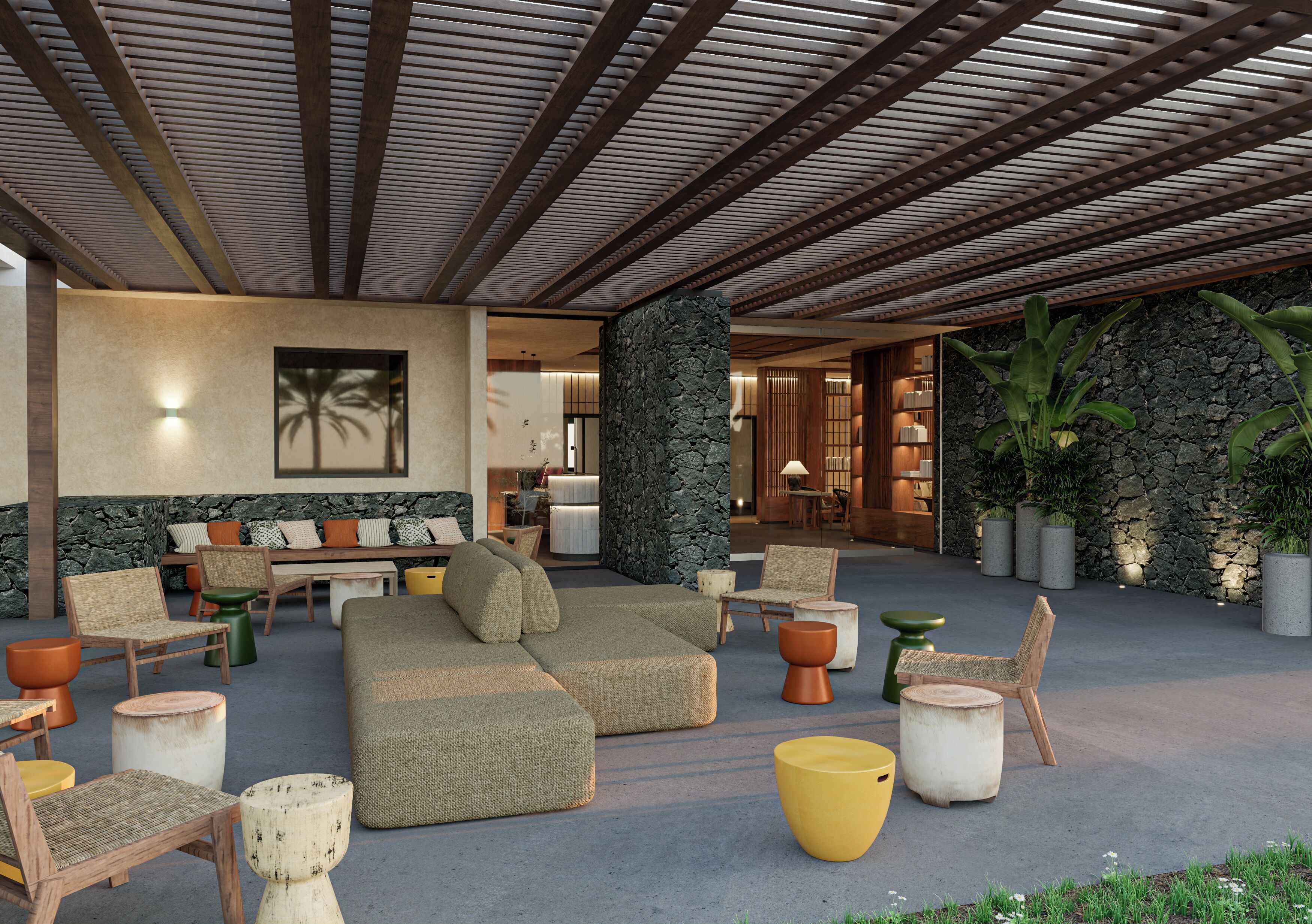 A covered outdoor seating area with a stone wall, wooden furniture, and potted plants.