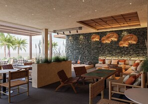 Un espace extérieur moderne, aménagé avec des murs en pierre, du mobilier en bois et offrant une vue sur des palmiers.