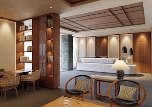A modern interior with a reception desk, seating area, bookshelves, and a stone pillar. -  HD Sensarena - Adults Only (Teguise)