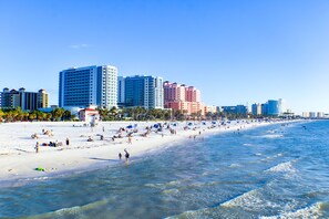 A beach with a row of high-rise hotels in the background. - Devon Shores (Clearwater Beach)