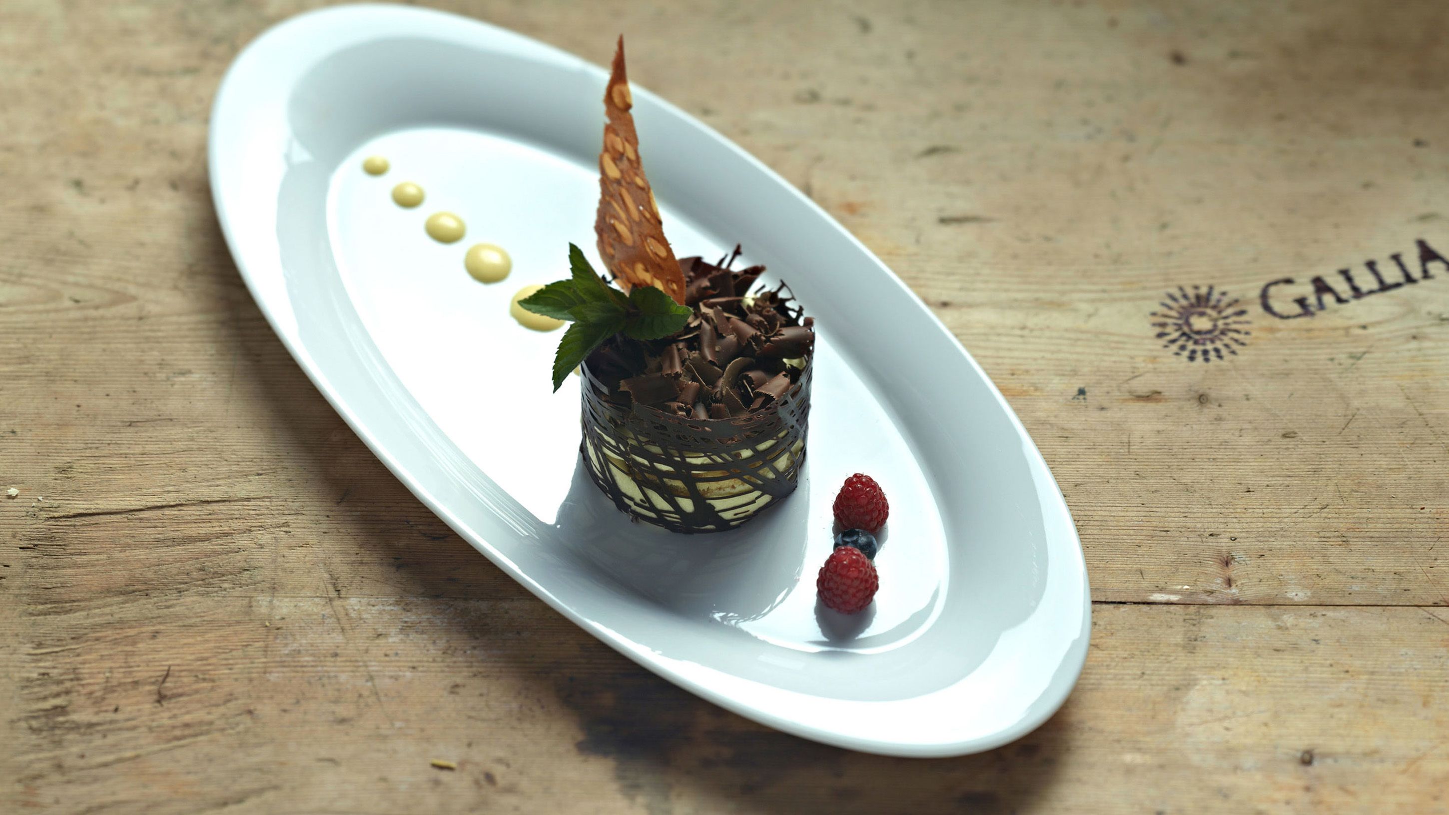 Un dessert servi sur une assiette blanche, avec une table en bois en arrière-plan.