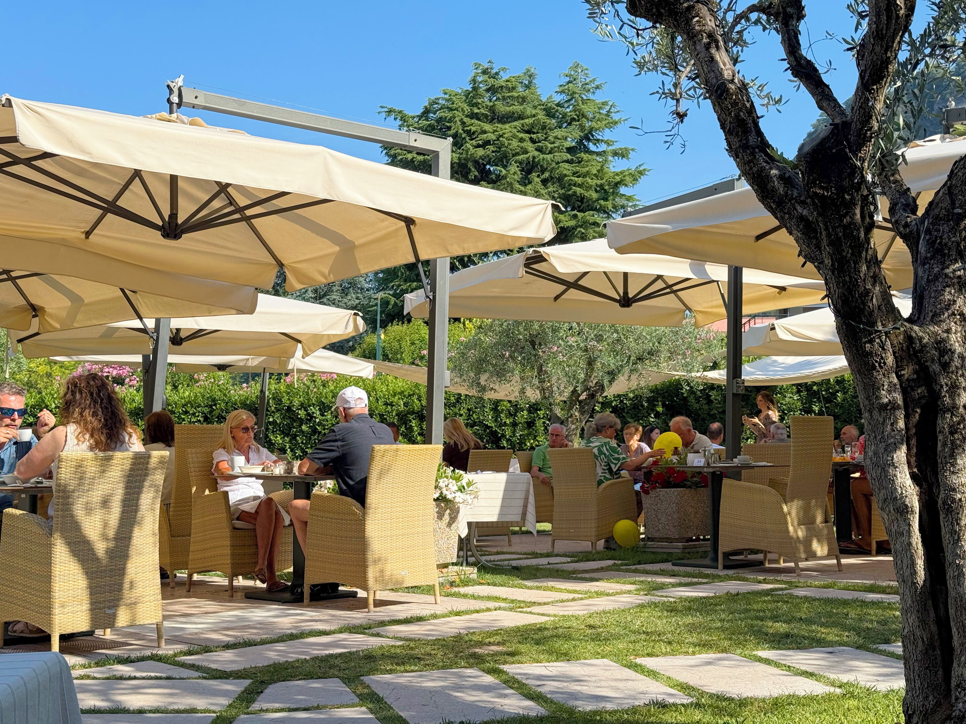 Espace extérieur aménagé avec des parasols, des meubles en osier et un chemin en pierre.