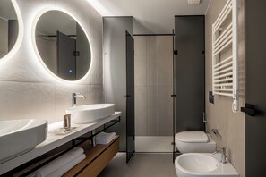 Une salle de bain moderne avec deux lavabos, une douche et des toilettes.