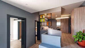 A modern interior with a staircase, a seating area, and a wooden cabinet. - NataLis Apartamentos (Pajara)