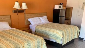 Une chambre d’hôtel avec deux lits, un four à micro-ondes, un réfrigérateur et un téléphone.
