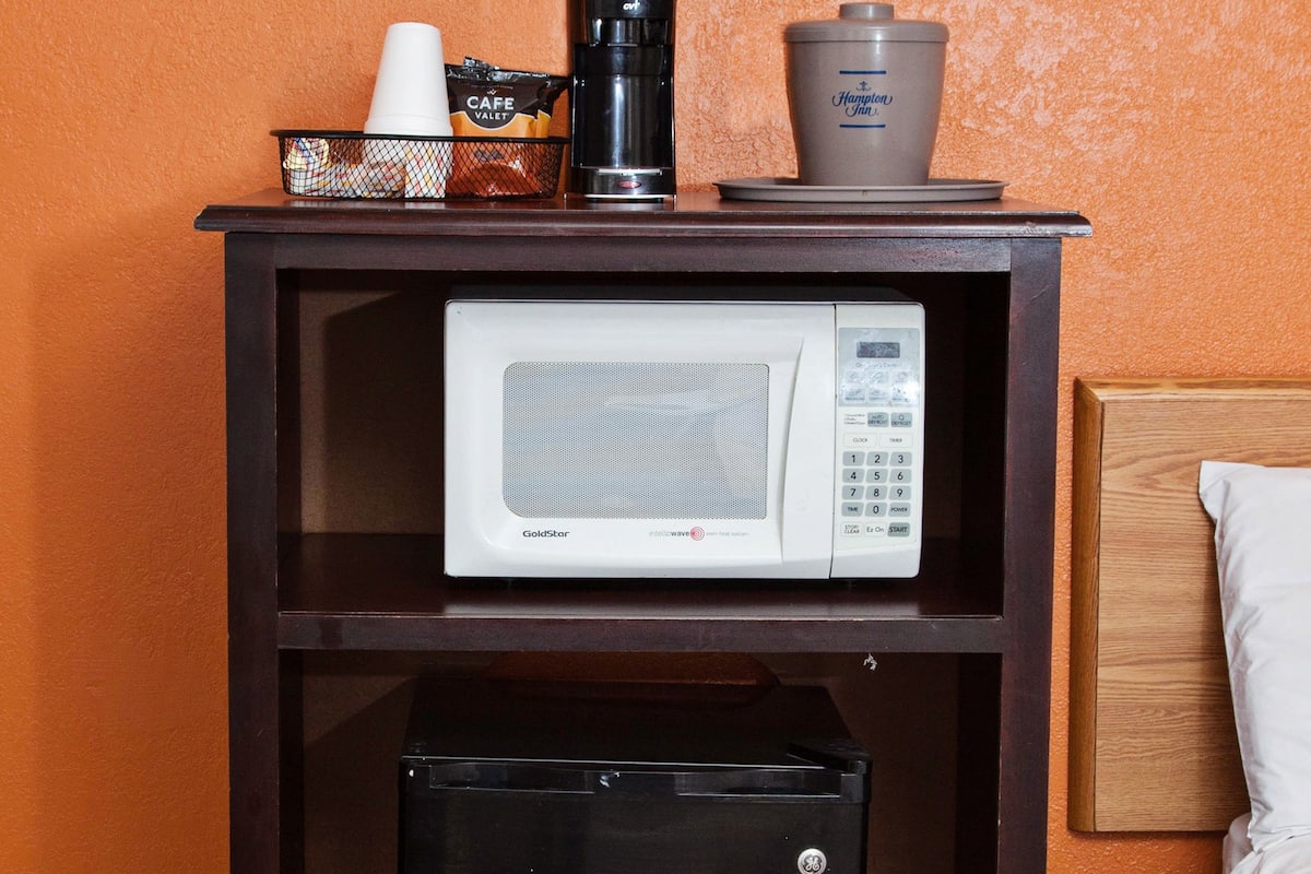 A compact kitchenette with a microwave, coffee maker, and a small refrigerator.
