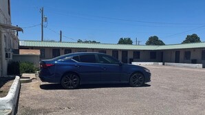 Une voiture bleue est garée devant un immeuble dont le toit est vert.