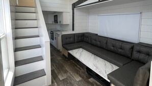 Et moderne interiør med trappe, hjørnesofa og et køkkenområde.