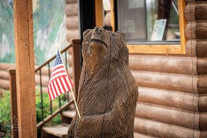 A wooden sculpture of a bear holding an American flag. - Teton Peaks Resort (Tetonia)