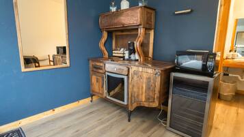 A compact kitchenette with a wooden cabinet, a microwave, and a small refrigerator.