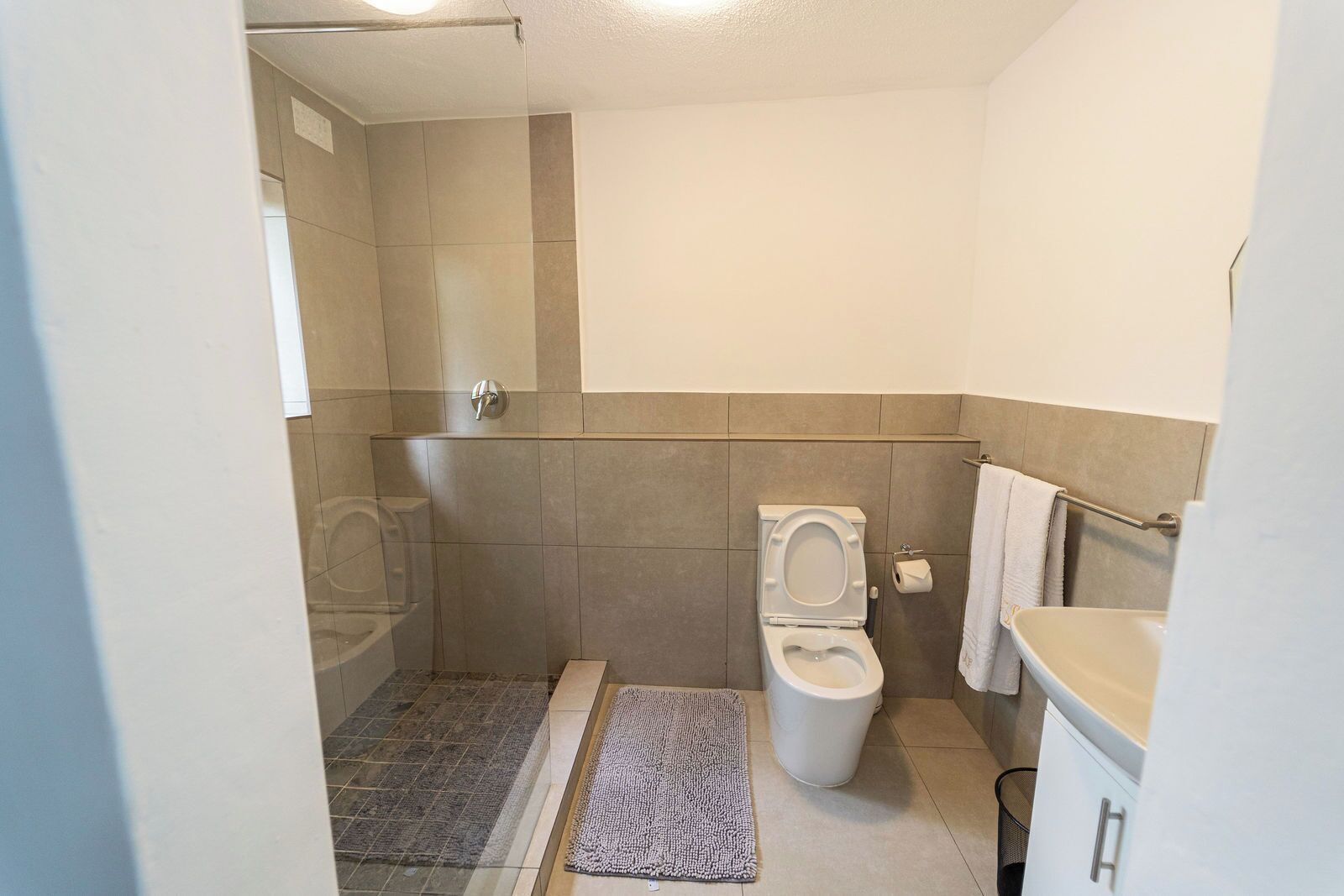 A bathroom with a shower, toilet, and sink.