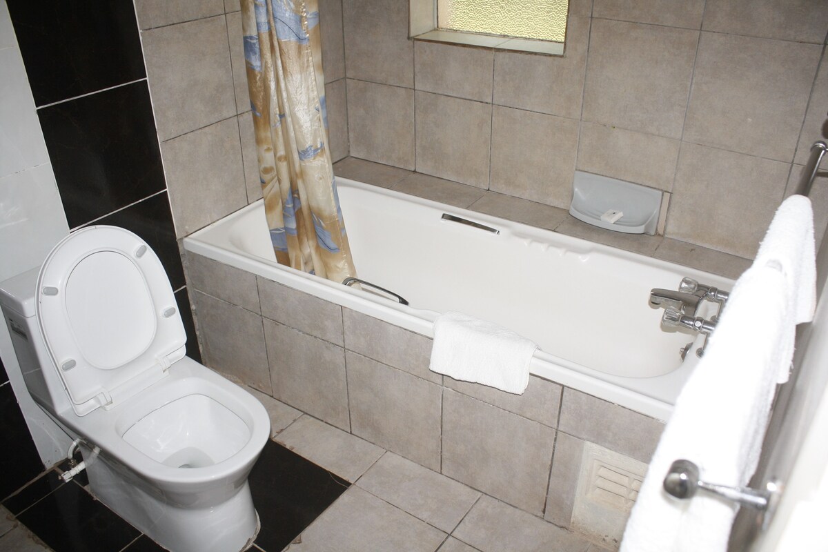 A bathroom with a toilet, bathtub, and shower curtain.