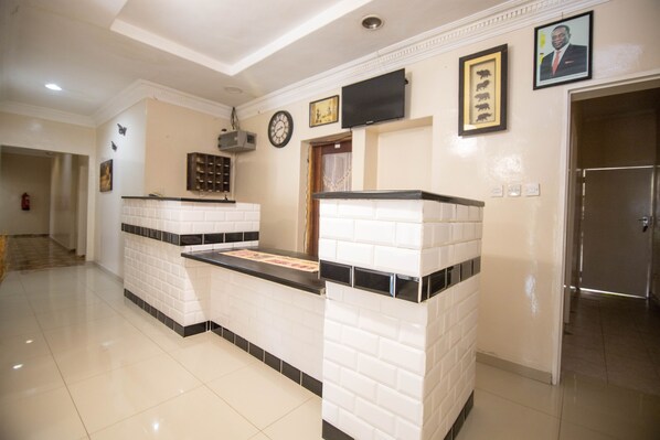 A reception area with a tiled counter, a clock, and framed artwork on the wall.