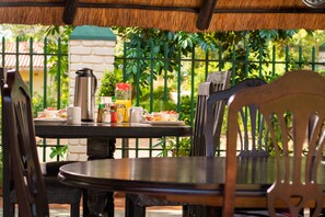 A table set for breakfast with a coffee pot, a jug, and a plate of food. - Wild Trekkers Lodge (Victoria Falls)