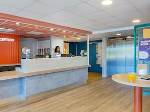 A reception area with a counter, a reception desk, and an elevator.