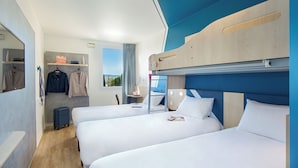 A hotel room with bunk beds, a suitcase, a mirror, and a window with a view. - ibis budget Valence Nord Plateau des Couleures (Saint-Marcel-les-Valence)