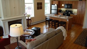 A spacious living room with a fireplace, a sofa, a coffee table, and a chessboard. - Butler House (Stowe)