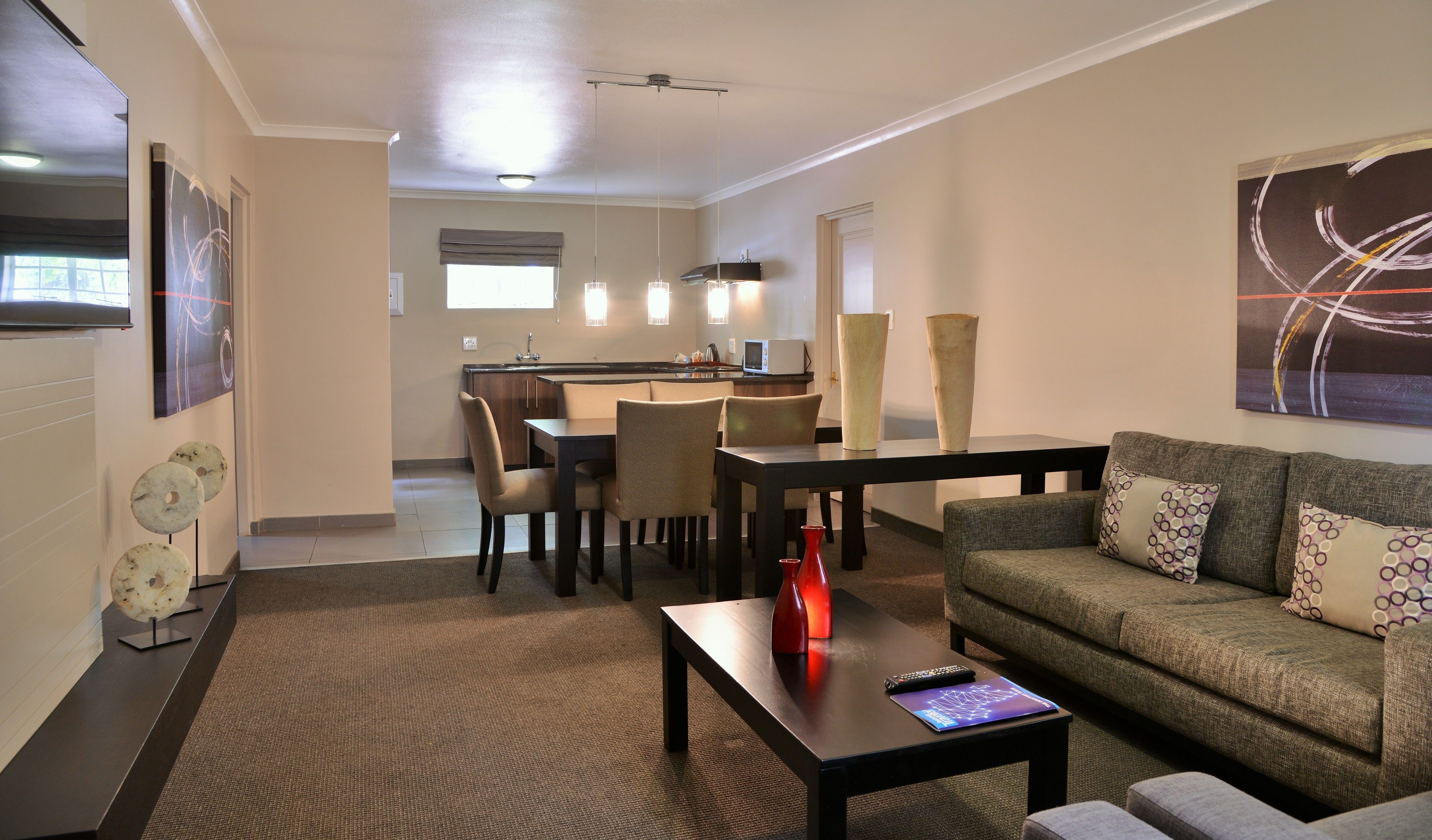 A modern living room with a sofa, coffee table, and dining area.