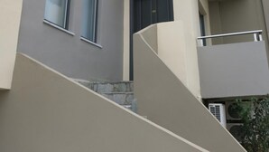 Ein mehrstöckiges Gebäude im modernen Architekturstil, mit Balkonen und großen Fenstern.