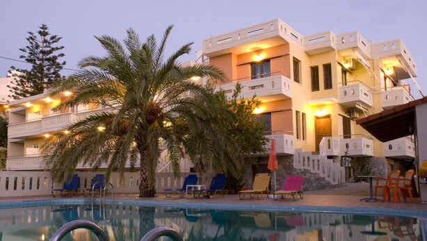 Ein Hotel mit Pool, Palmen und Außenbereich.