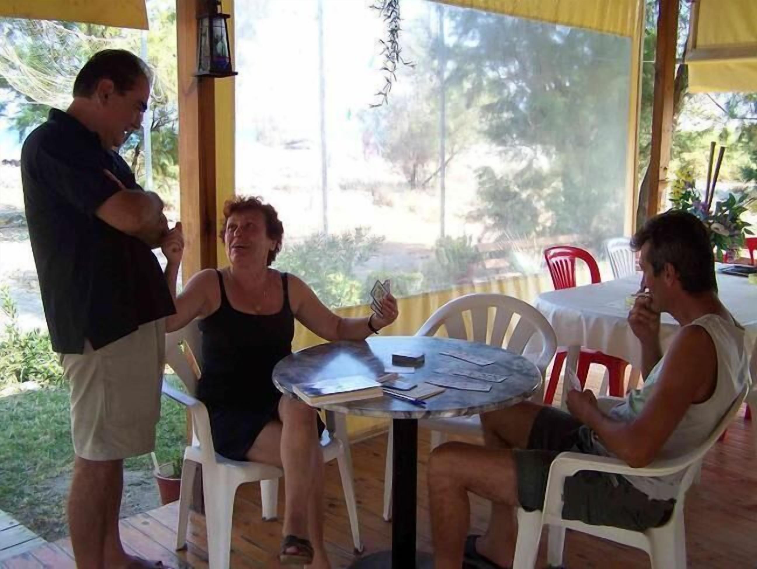 Un espacio de descanso al aire libre con techo, una mesa redonda y sillas.